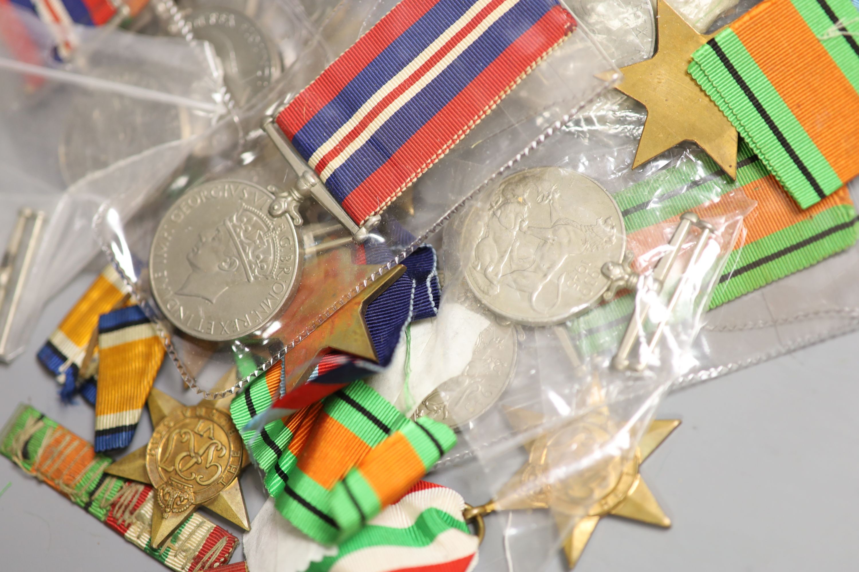 A large collection of unnamed WWII medals and spare ribbons and a cased QEII Imperial Service Medal to John Henry Hope